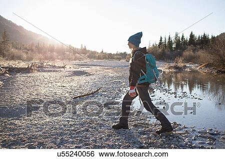 Stock Photograph - Young female hiker hiking along lakeside in Bavarian Alps. Fotosearch