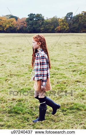 Stock Photo - Young girl, walking through field. Fotosearch
