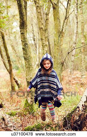 Stock Photo - Young girl, walking through forest. Fotosearch