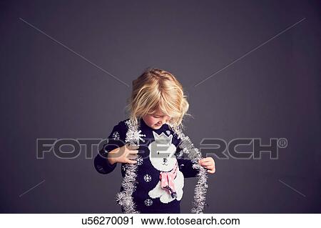 Young girl wearing Christmas jumper and tinsel around neck View Large Photo Image Stock Image - Young girl wearing Christmas jumper and tinsel around neck. Fotosearch