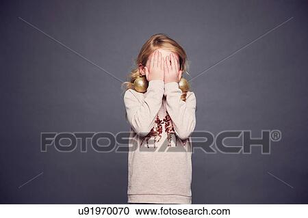Young girl wearing Christmas jumper and bauble earrings, covering face with hands View Large Photo Image Stock Image - Young girl wearing Christmas jumper and bauble earrings, covering face with hands. Fotosearch