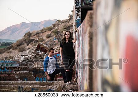 Young man and woman exploring graffiti walls at ruined mine View Large Photo Image Stock Photo - Young man and woman exploring graffiti walls at ruined mine. Fotosearch
