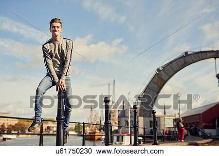 Stock Image - Young man leaping bollard, Bristol, UK. Fotosearch