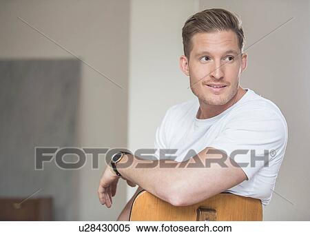 Young man sitting chair looking over his shoulder View Large Photo Image Stock Photography - Young man sitting chair looking over his shoulder. Fotosearch