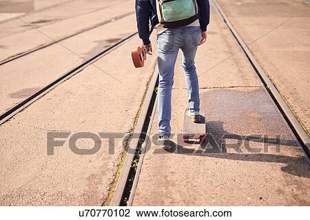 Young man skateboarding between tramlines, rear view, low section, Bristol, UK View Large Photo Image Stock Image - Young man skateboarding between tramlines, rear view, low section, Bristol, UK. Fotosearch