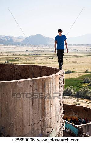 Young man walking on top of tower at ruined mine View Large Photo Image Stock Photograph - Young man walking on top of tower at ruined mine. Fotosearch