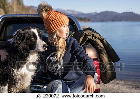 Young woman and dog looking out from pick up on lakeside in Bavarian Alps View Large Photo Image Stock Image - Young woman and dog looking out from pick up on lakeside in Bavarian Alps. Fotosearch