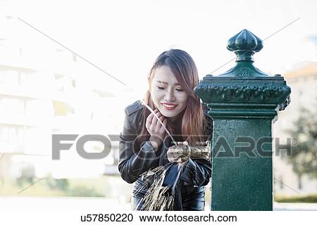 Young woman at drinking fountain, Milan, Italy View Large Photo Image Stock Image - Young woman at drinking fountain, Milan, Italy. Fotosearch