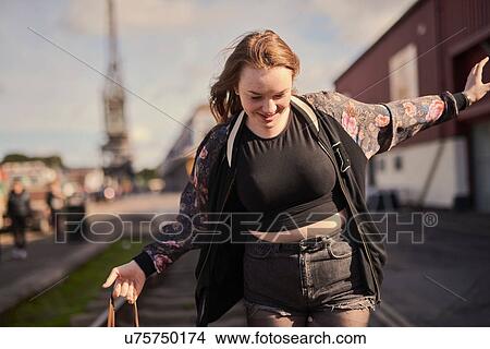 Picture - Young woman balancing on train track, Bristol, UK. Fotosearch