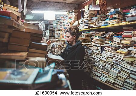 Young woman browsing in stacked book shop, Venice, Italy View Large Photo Image Picture - Young woman browsing in stacked book shop, Venice, Italy. Fotosearch