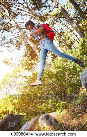 Young woman, hiking, jumping from one rock to another, Cape Town, South Africa View Large Photo Image Picture - Young woman, hiking, jumping from one rock to another, Cape Town, South Africa. Fotosearch