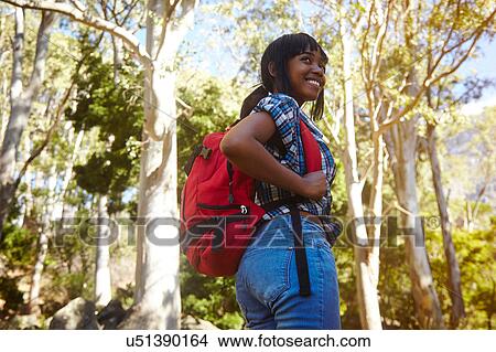 Young woman hiking through forest, looking over shoulder, smiling, Cape Town, South Africa View Large Photo Image Picture - Young woman hiking through forest, looking over shoulder, smiling, Cape Town, South Africa. Fotosearch