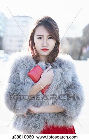 Stock Image - Young woman in fur coat, Milan, Italy. Fotosearch