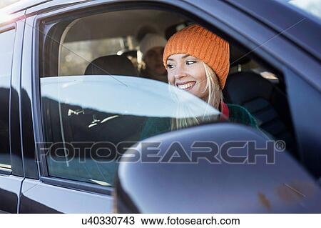 Young woman in knit hat looking out of car window View Large Photo Image Stock Image - Young woman in knit hat looking out of car window. Fotosearch