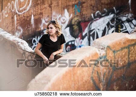 Young woman leaning against graffiti wall mine ruins View Large Photo Image Stock Photo - Young woman leaning against graffiti wall mine ruins. Fotosearch