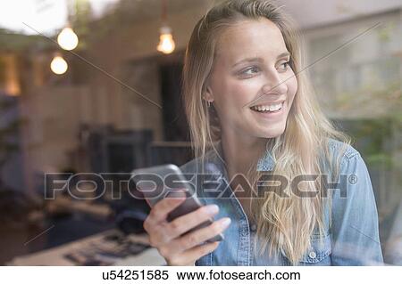 Young woman looking sideways through cafe window View Large Photo Image Stock Photography - Young woman looking sideways through cafe window. Fotosearch