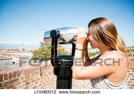 Young woman looking through coin operated binoculars from the Monte dei Cappuccini, Turin, Italy View Large Photo Image Stock Image - Young woman looking through coin operated binoculars from the Monte dei Cappuccini, Turin, Italy. Fotosearch