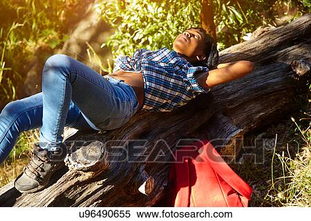 Stock Photography - Young woman lying on fallen tree, Cape Town, South Africa. Fotosearch