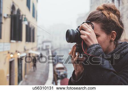 Young woman photographing on misty canal waterfront, Venice, Italy View Large Photo Image Stock Image - Young woman photographing on misty canal waterfront, Venice, Italy. Fotosearch