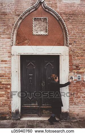Young woman ringing doorbell of old building, Venice, Italy View Large Photo Image Stock Image - Young woman ringing doorbell of old building, Venice, Italy. Fotosearch