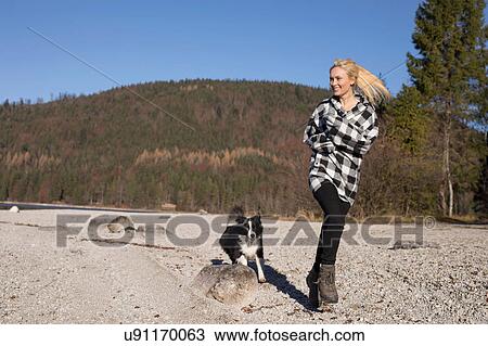 Young woman running on lakeside with dog in Bavarian Alps View Large Photo Image Stock Image - Young woman running on lakeside with dog in Bavarian Alps. Fotosearch