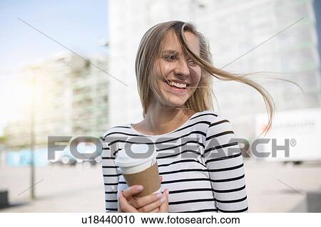 Young woman with blond flyaway hair with takeaway coffee View Large Photo Image Stock Image - Young woman with blond flyaway hair with takeaway coffee. Fotosearch