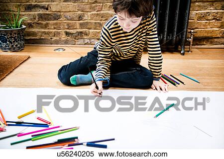 Boy sitting on floor drawing on large paper View Large Photo Image Stock Photography - Boy sitting on floor drawing on large paper. Fotosearch