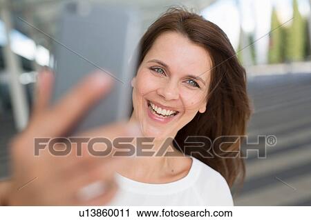 Businesswoman taking smartphone selfie outside airport View Large Photo Image Stock Image - Businesswoman taking smartphone selfie outside airport. Fotosearch