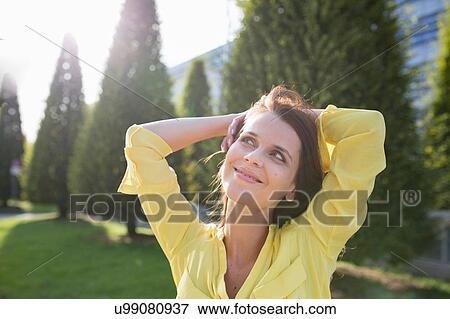 Businesswoman with hands behind head at airport View Large Photo Image Stock Photo - Businesswoman with hands behind head at airport. Fotosearch
