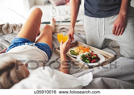 Couple having breakfast in bed, mid section View Large Photo Image Stock Photograph - Couple having breakfast in bed, mid section. Fotosearch