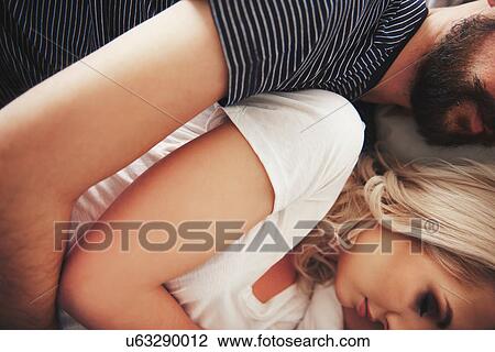 Couple lying in bed, hugging, mid section, close-up View Large Photo Image Stock Image - Couple lying in bed, hugging, mid section, close-up. Fotosearch