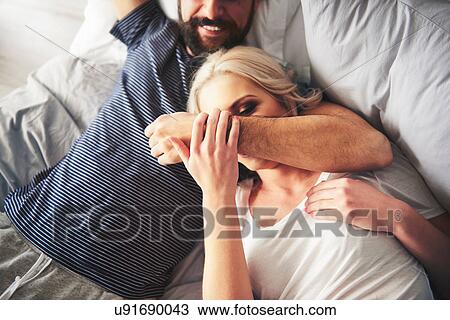 Couple relaxing on bed, fooling around View Large Photo Image Stock Image - Couple relaxing on bed, fooling around. Fotosearch