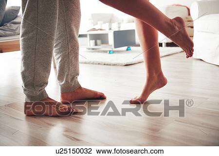Stock Image - Couple standing face to face, woman leaning into man, low section. Fotosearch