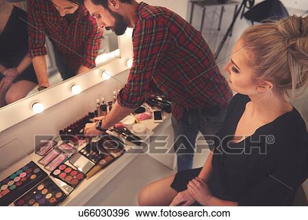 Stock Photograph - Male make up artist selecting make up for photo shoot. Fotosearch
