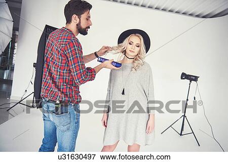 Male photographer adjusting female model's hair on studio white background View Large Photo Image Stock Photo - Male photographer adjusting female model's hair on studio white background. Fotosearch