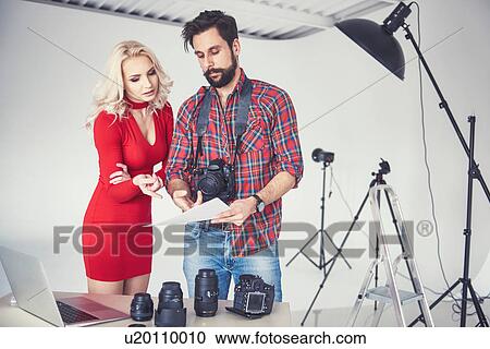 Male photographer and model looking at photographs from photo shoot in studio View Large Photo Image Stock Image - Male photographer and model looking at photographs from photo shoot in studio. Fotosearch