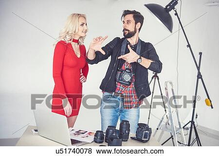 Stock Photo - Male photographer explaining to female model for studio photo shoot. Fotosearch
