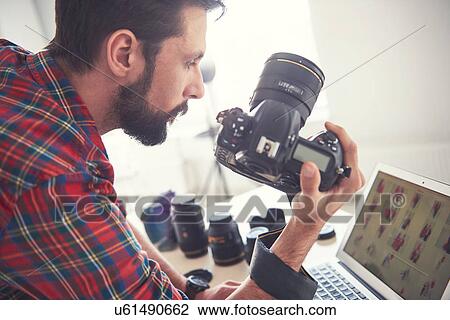 Male photographer reviewing photo shoot on laptop in studio View Large Photo Image Stock Image - Male photographer reviewing photo shoot on laptop in studio. Fotosearch