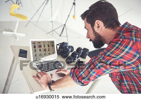 Male photographer reviewing photo shoot on laptop in studio View Large Photo Image Stock Photography - Male photographer reviewing photo shoot on laptop in studio. Fotosearch