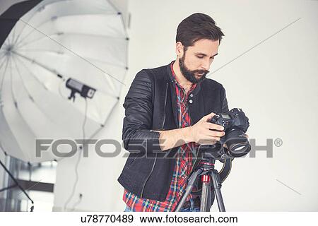 Male photographer reviewing studio photo shoot on digital slr View Large Photo Image Stock Photo - Male photographer reviewing studio photo shoot on digital slr. Fotosearch
