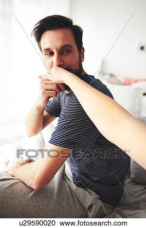 Man sitting on bed, kissing woman's hand View Large Photo Image Stock Image - Man sitting on bed, kissing woman's hand. Fotosearch