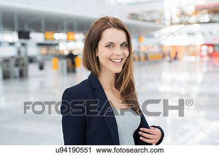 Stock Image - Portrait of businesswoman in airport departure lounge. Fotosearch
