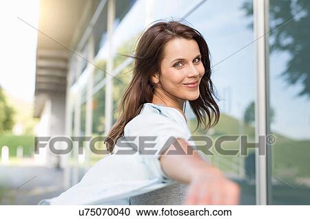 Stock Image - Portrait of happy businesswoman outside airport. Fotosearch