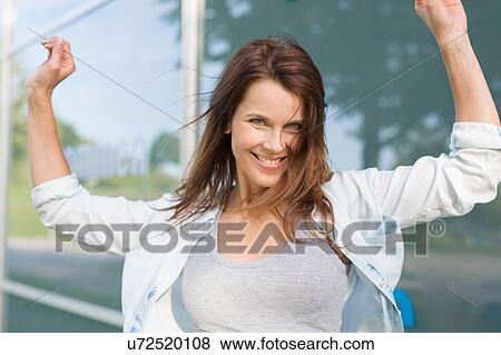 Portrait of happy mid adult woman outside glass fronted building View Large Photo Image Stock Photo - Portrait of happy mid adult woman outside glass fronted building. Fotosearch