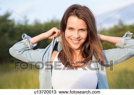 Portrait of woman with hands behind head in field View Large Photo Image Stock Image - Portrait of woman with hands behind head in field. Fotosearch
