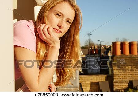 Portrait of young woman, leaning out of window, resting on hand View Large Photo Image Stock Photo - Portrait of young woman, leaning out of window, resting on hand. Fotosearch
