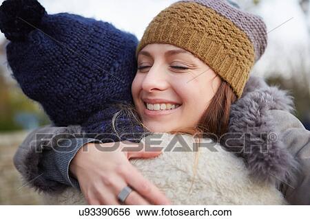 Stock Photograph - Two female friends, outdoors, hugging. Fotosearch