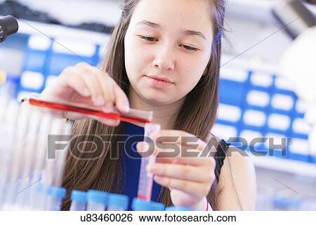 Stock Photograph - Chemistry student pouring liquid into test tube. Fotosearch