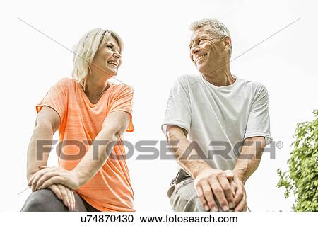 Stock Image - Couple smiling, low angle view. Fotosearch