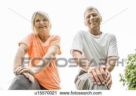 Couple smiling towards camera, low angle view View Large Photo Image Stock Image - Couple smiling towards camera, low angle view. Fotosearch